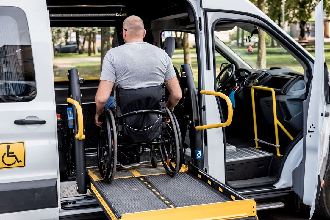 persona en silla de ruedas montando en vehículo adaptado